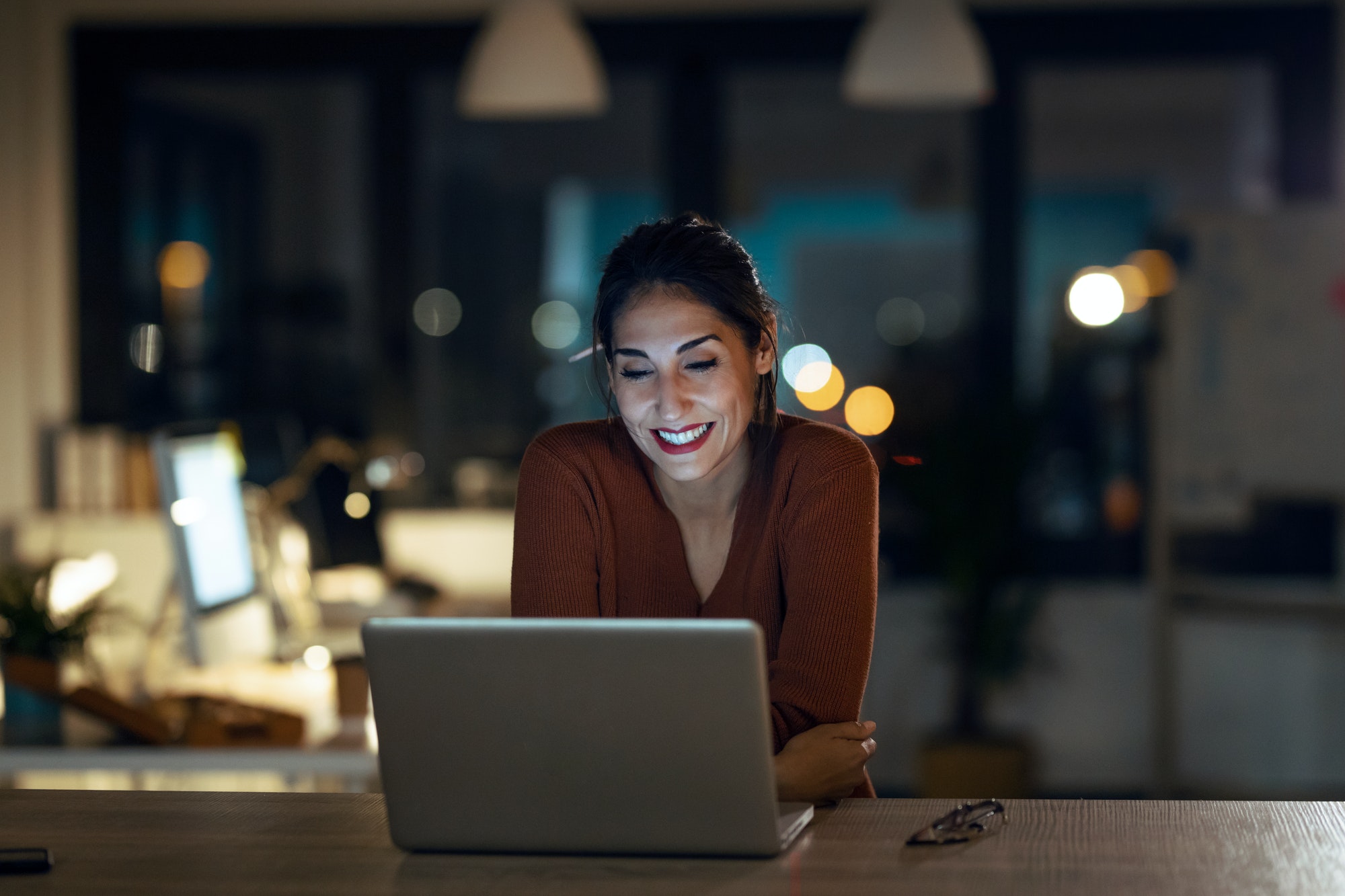 smiling beautiful business woman having an online video call via laptop computer in the office